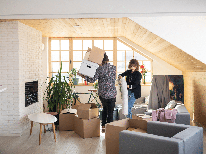 A couple moving packages out of their house.