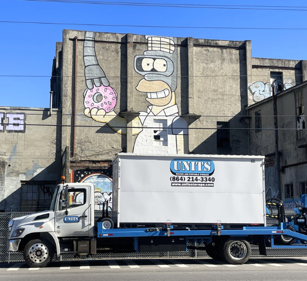 UNITS of Asheville portable storage delivery truck in front of the Waste Paper Mill Murals.