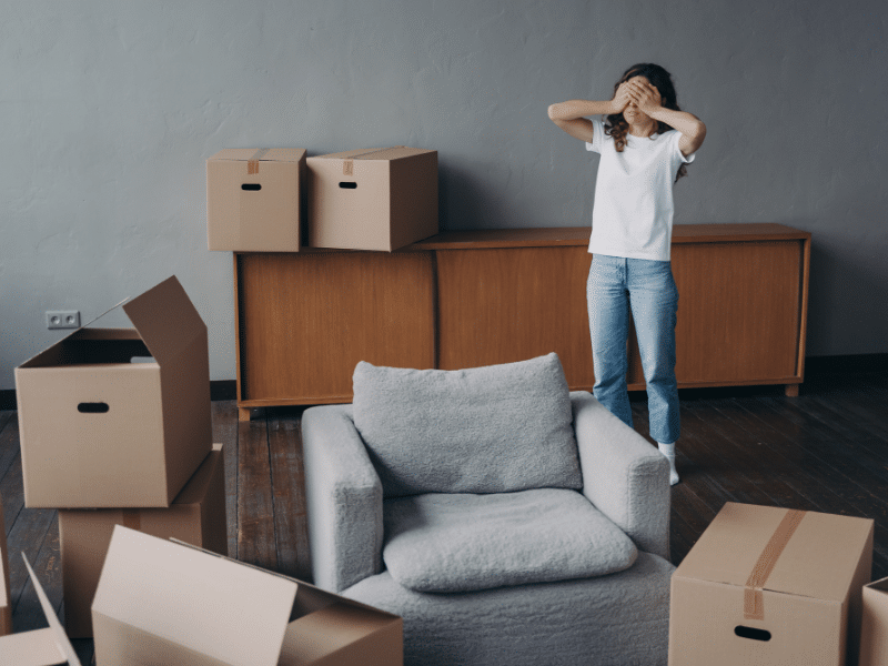 a woman surround by unlabeled boxes after making one of the common Moving Mistakes