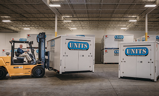 A Units Of Fort Collins container getting stacked in a warehouse.