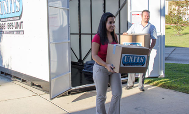 A couple unpacking boxes from a Units Of Fort Collins container.