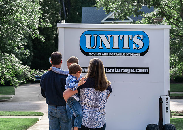 Family standing in front of UNITS Moving and Portable Storage container in their driveway in Baltimore Maryland