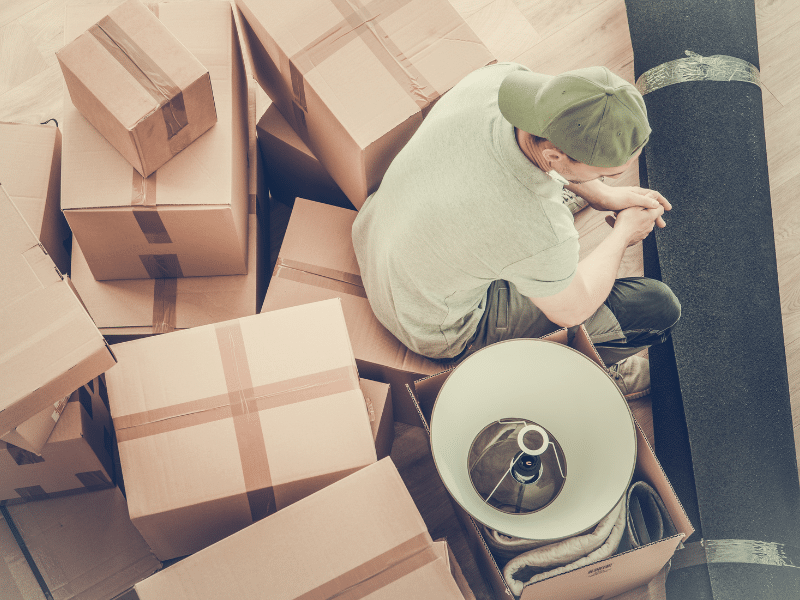 man sitting surrounded by boxes after his Move
