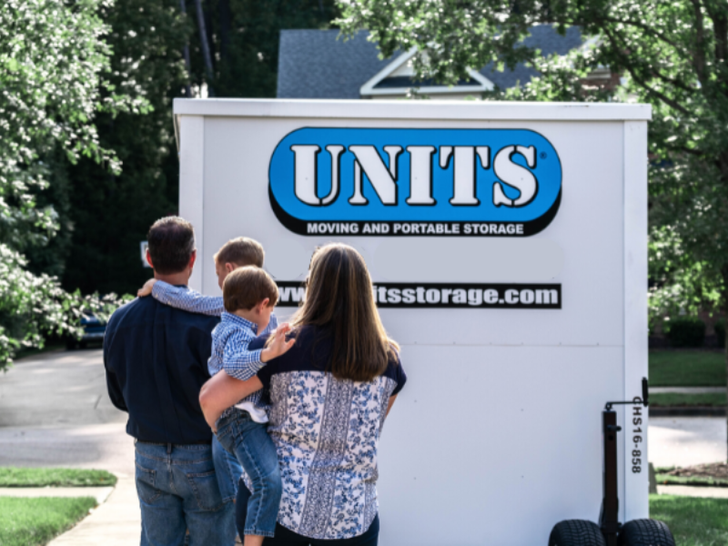 family in front of UNITS container