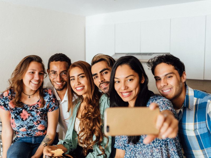 Group of friends taking a selfie in a kitchen.