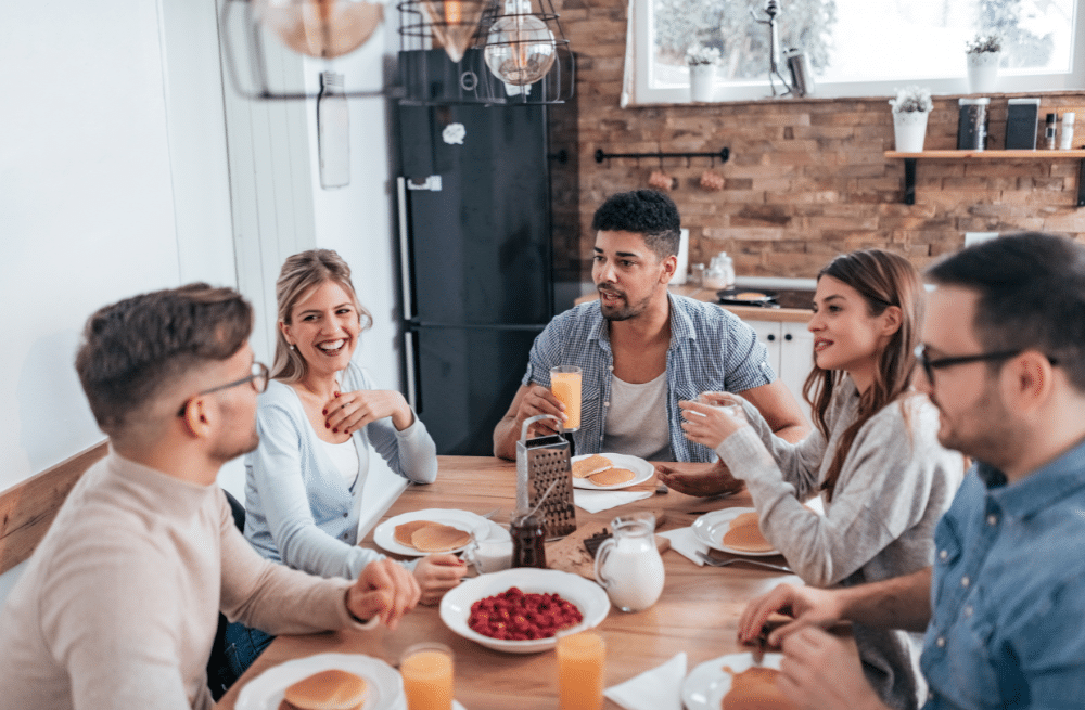 A group of people sitting at a table eating breakfast.