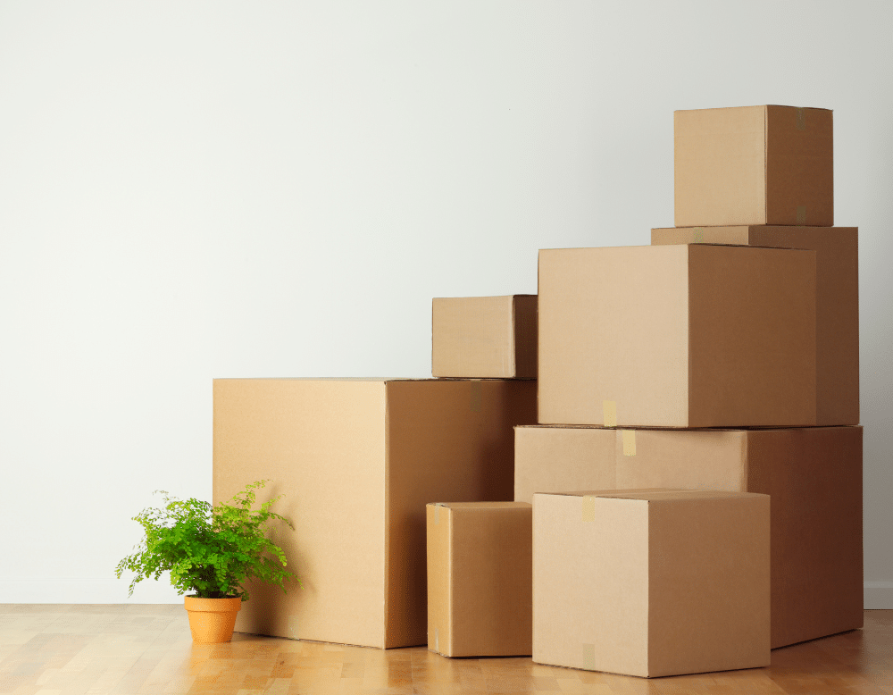 Cardboard boxes stacked on the floor in a room.