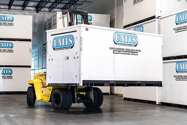 A Units Of Fort Collins container getting stacked in a warehouse.