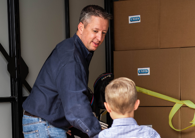 Man showing a young boy how to store boxes properly in their UNITS Moving and Portable Storage Container.
