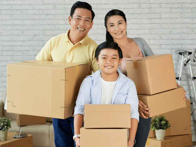 Happy family each holding cardboard boxes.