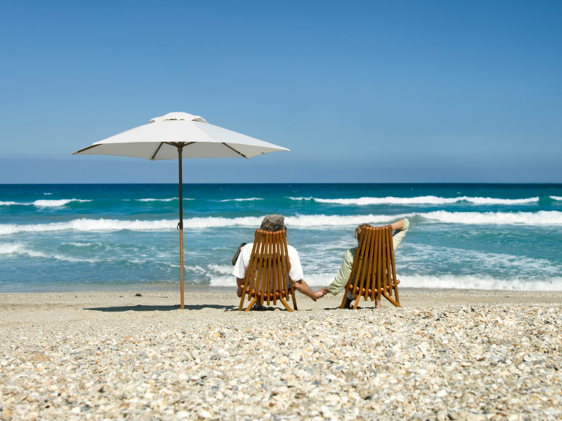 old couple relaxing on the beach in on of the Retirement States