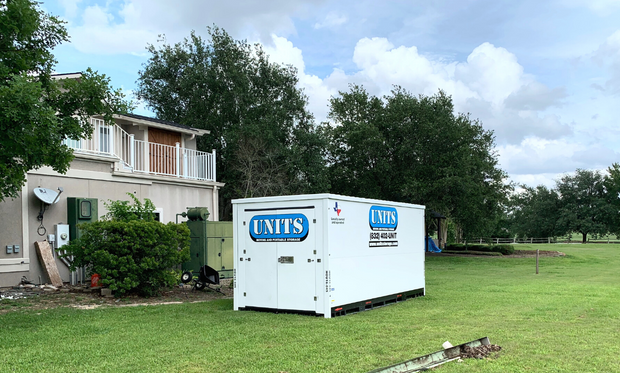 A Units of Houston Gulf Coast container sitting in the backyard of a house.