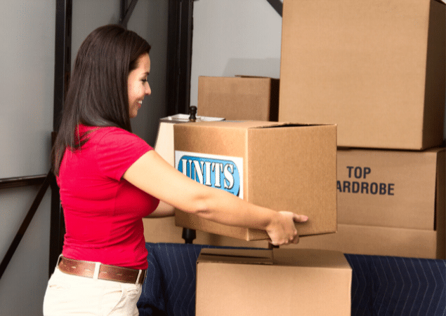 Woman putting cardboard boxes into a portable storage container.