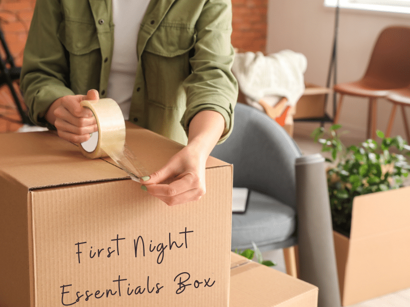 Person taping a cardboard box labeled First Night Essentials Box closed.