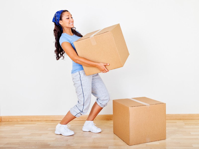 woman lifting a heavy box during her move