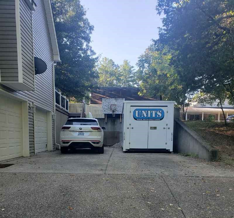 A Units Of Louisville container sitting in a driveway.