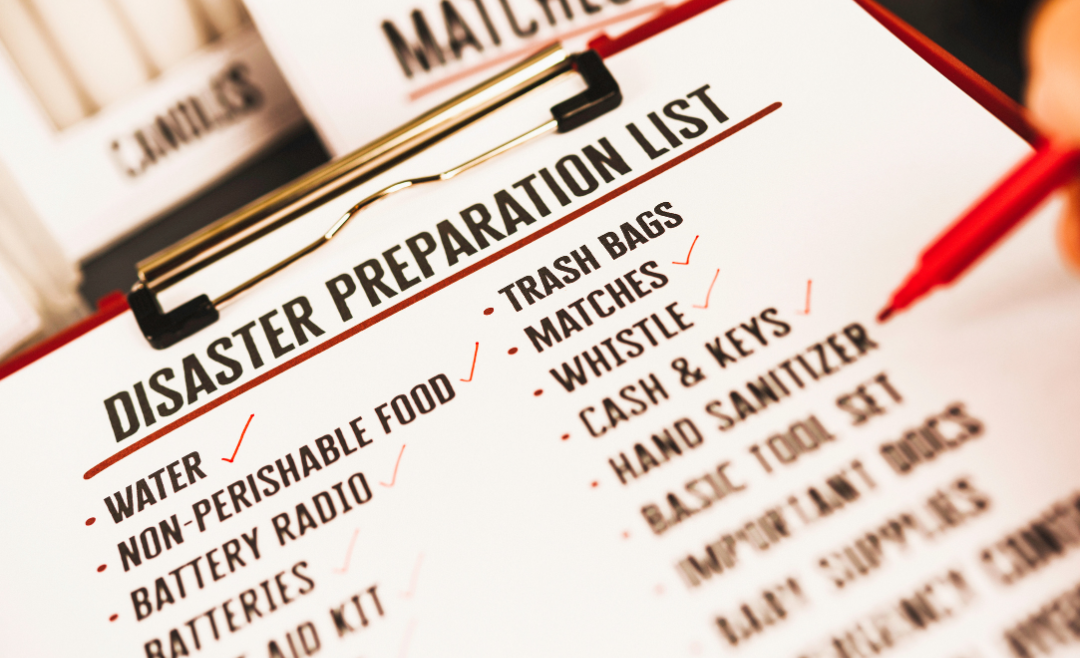 A person checking off items on a disaster preparation list.