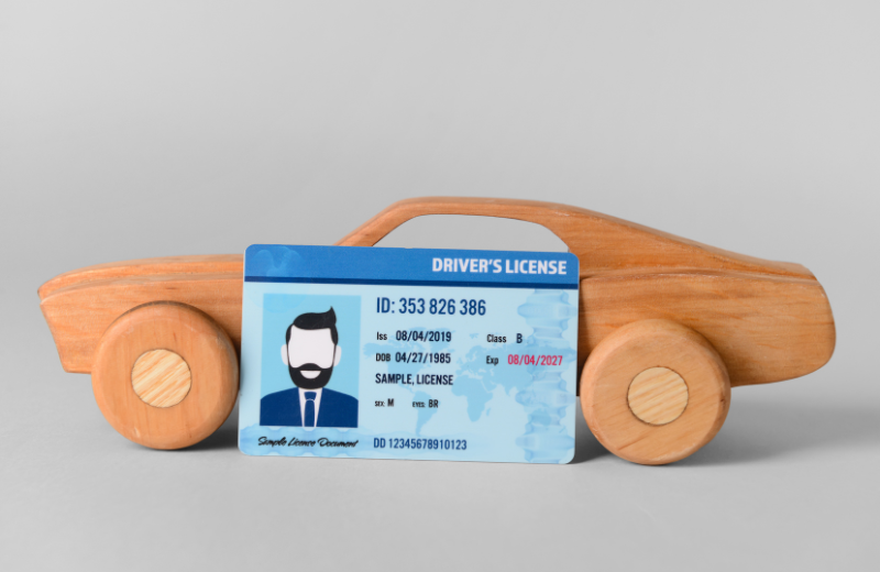 A fake drivers license in front of a toy.