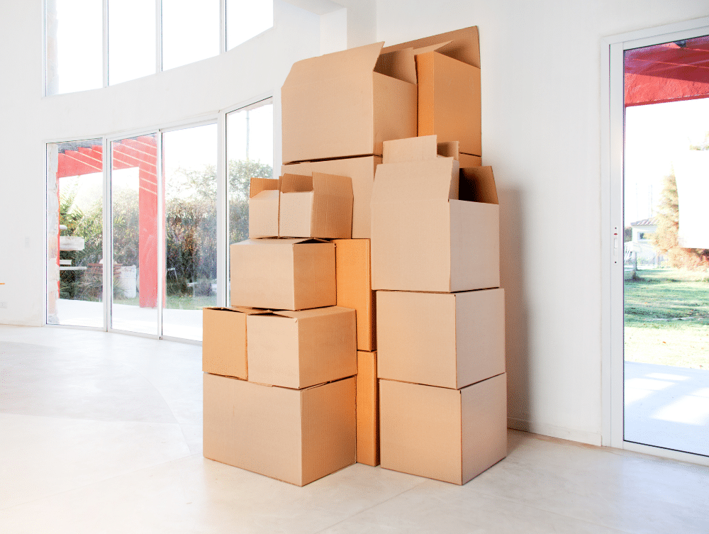 Cardboard boxes stacked on top of each other against a wall.