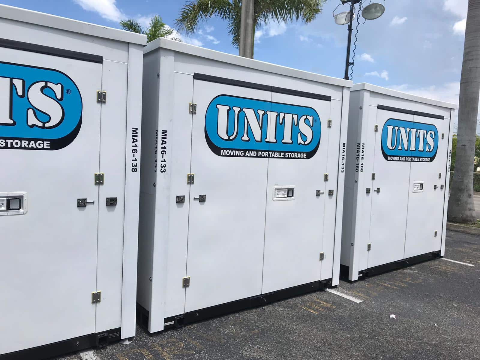 3 UNITS Moving and Portable Storage of Miami containers sitting in a parking lot next to each other.