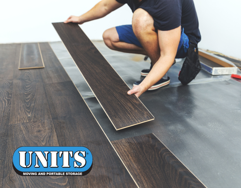 a pic of a person putting down a hardwood floor with units logo