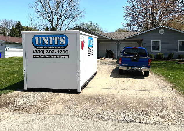 A Units Of Northeast Ohio container sitting in the driveway of a house.