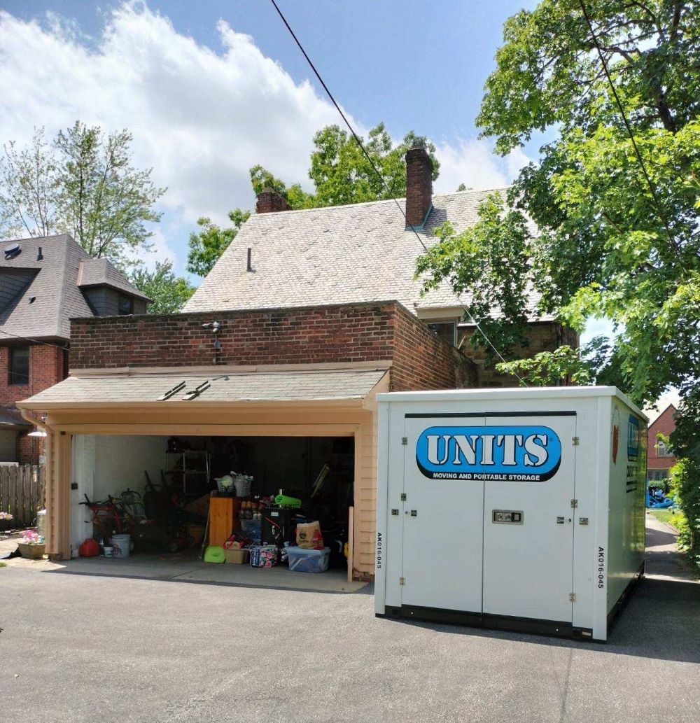 A Units Of Northeast Ohio container sitting n the driveway of a house.