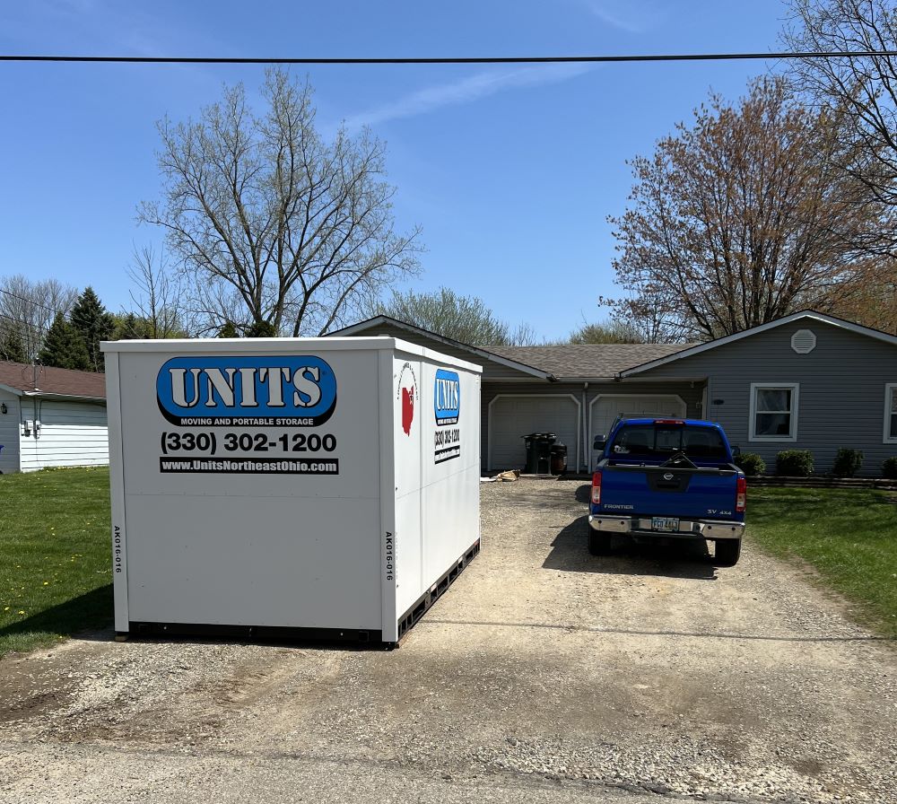 A Units Of Northeast Ohio container sitting in the driveway of a house.