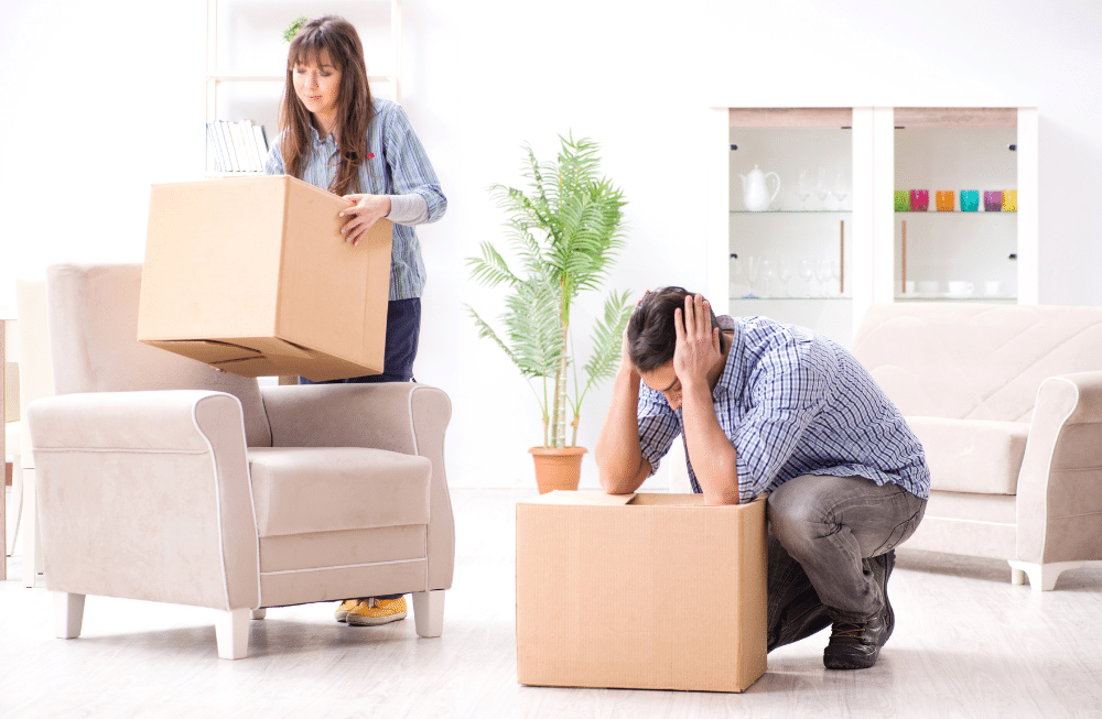 A woman and a man unpacking boxes in their new home.