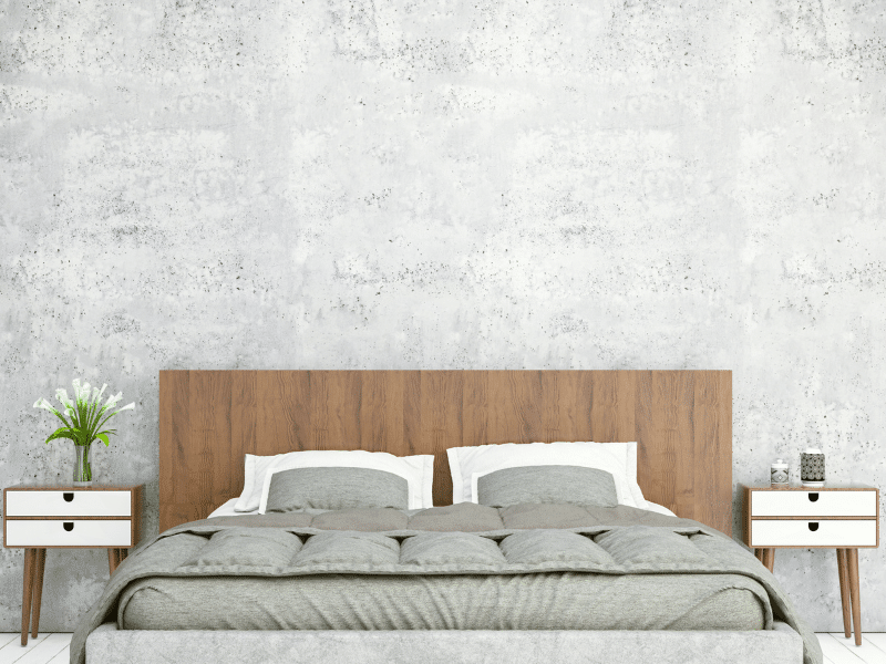 A bedroom that is clean and decorated with gray sheets and gray walls.