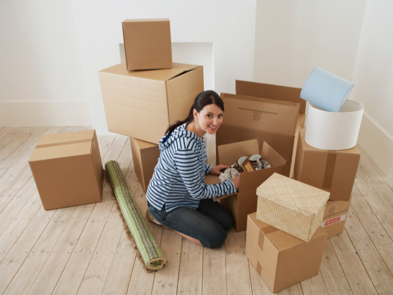 Woman packing her office away in cardboard boxes.