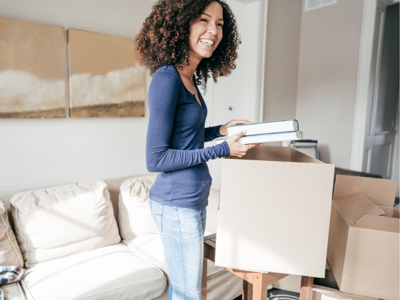 Woman smiling while packing her belongings.