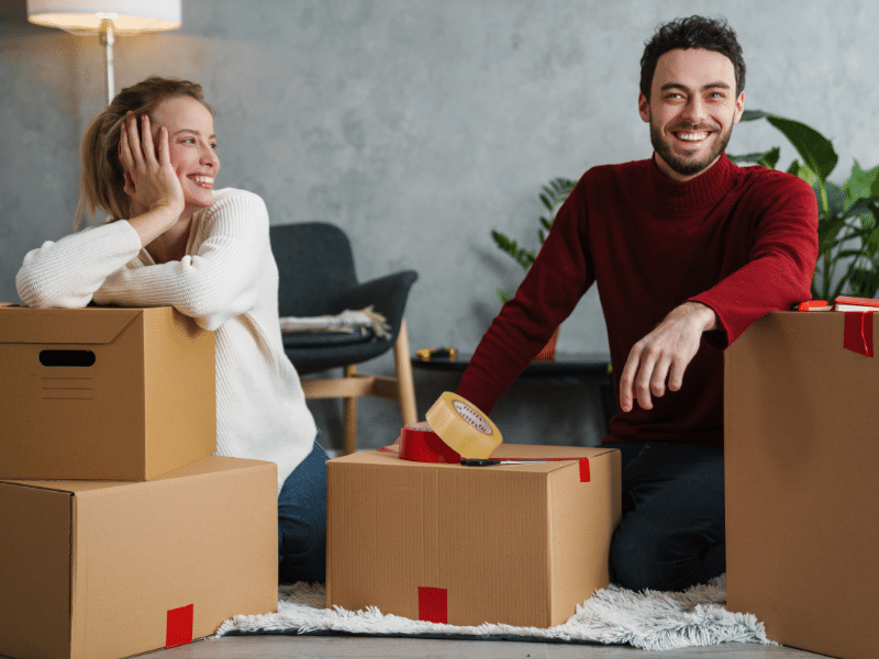 Couple sitting on the floor packing boxes.