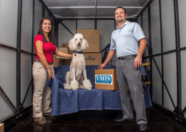 Man and woman standing in an empty UNITS Moving and Portable Storage of San Diego container with a dog.