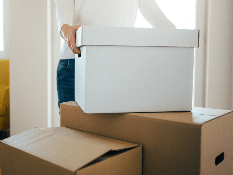 A person holding a box getting ready to move to a new home.