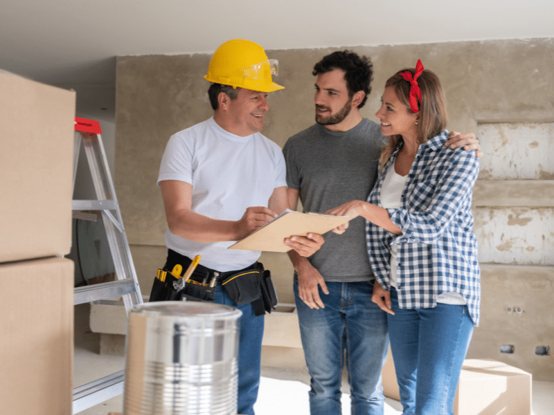 couple discussing a home remodel before listing it for sale with contractor