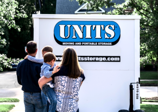 Family standing in a driveway looking at their UNITS Moving and Portable Storage container.