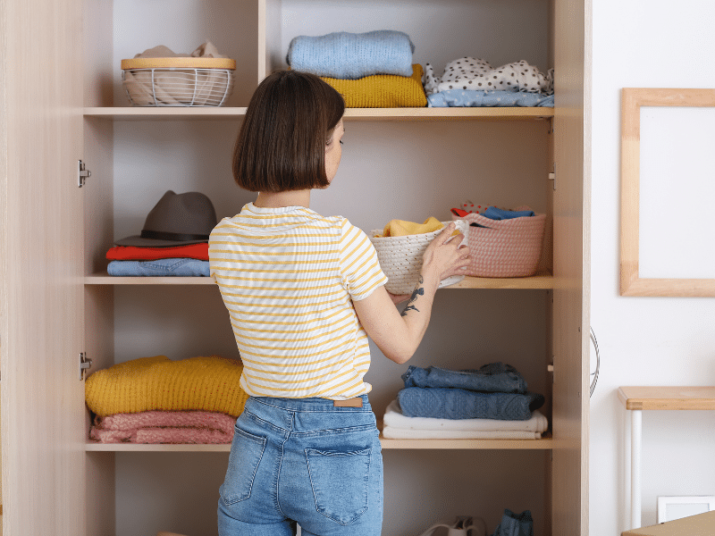 A women in her closet organizing her belongings.