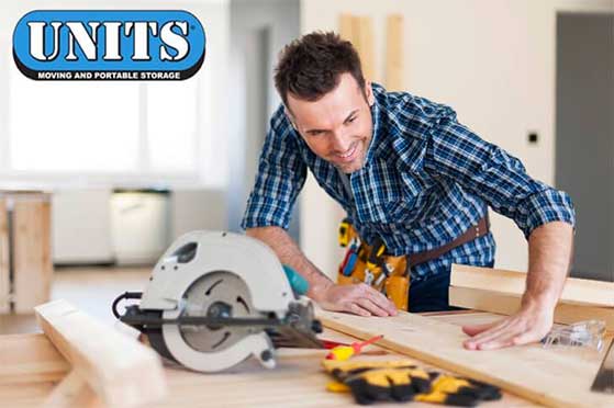 Man cutting wood with the units logo in the top left.