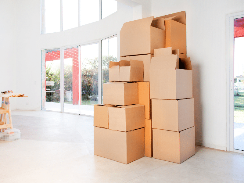 Transitioning From an Apartment to a House with a tall stack of boxes in a new home