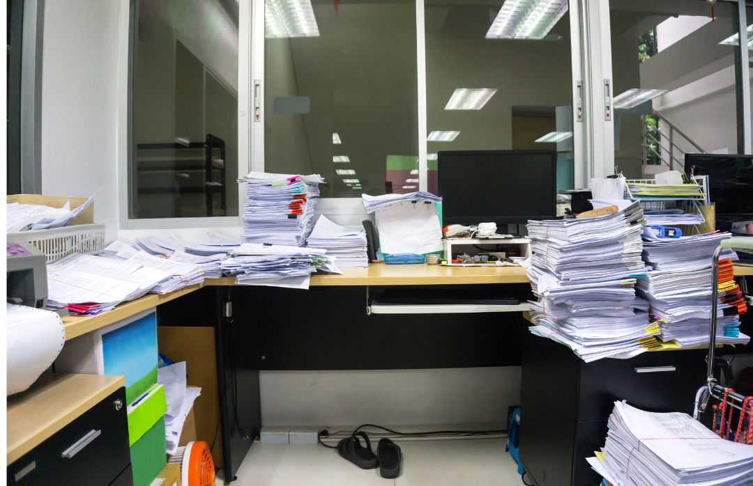 Office that is cluttered with papers that are not organized.
