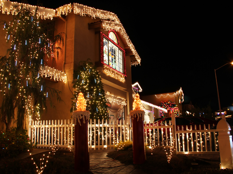 House decorated for the holidays with lights and Christmas trees.