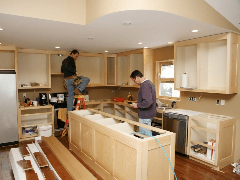 Two men building a kitchen.