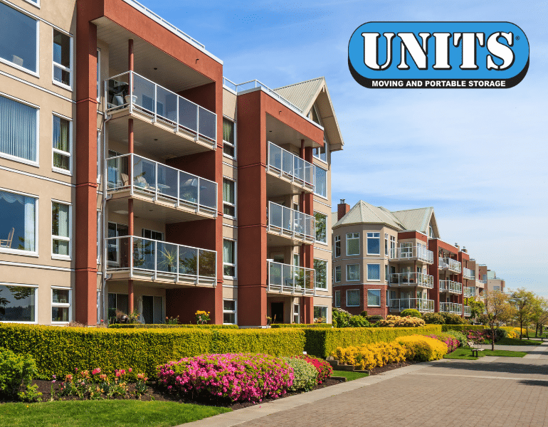 Apartment complex with beautiful landscape, with UNITS Moving and Portable Storage logo.
